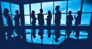 several-colleagues-communicating-in-office-against-window-SBI-300726181